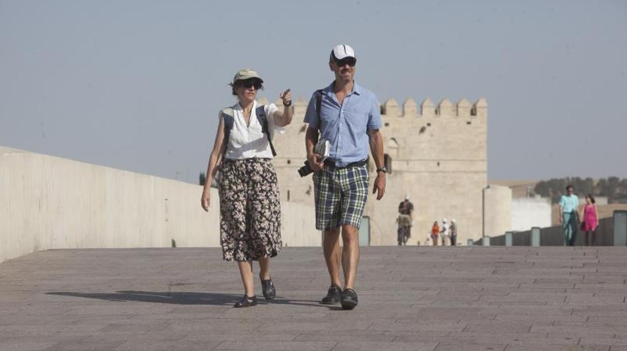 Una pareja pasea por el Puente Romano de Córdoba