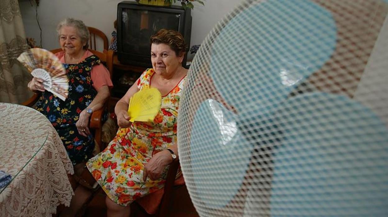 Dos mujeres mayores se abanican en su casa en Córdoba