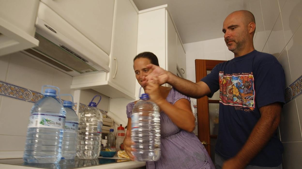 Una familia acopia agua ante un corte del servicio