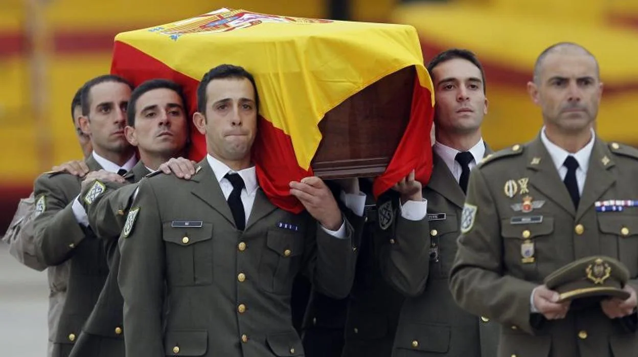 Compañeros del regimiento Garellano 45 trasladan el féretro de Joaquín Moya a su llegada a España, el 7 de noviembre de 2011