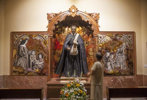 Una mujer admira la escultura del Beato Cristóbal de Santa Catalina