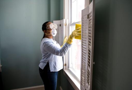 Empleada de hogar con mascarilla y guantes por la pandemia