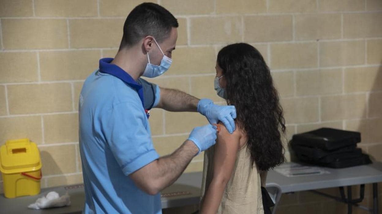 Un enfermero pone una vacuna a una adolescente