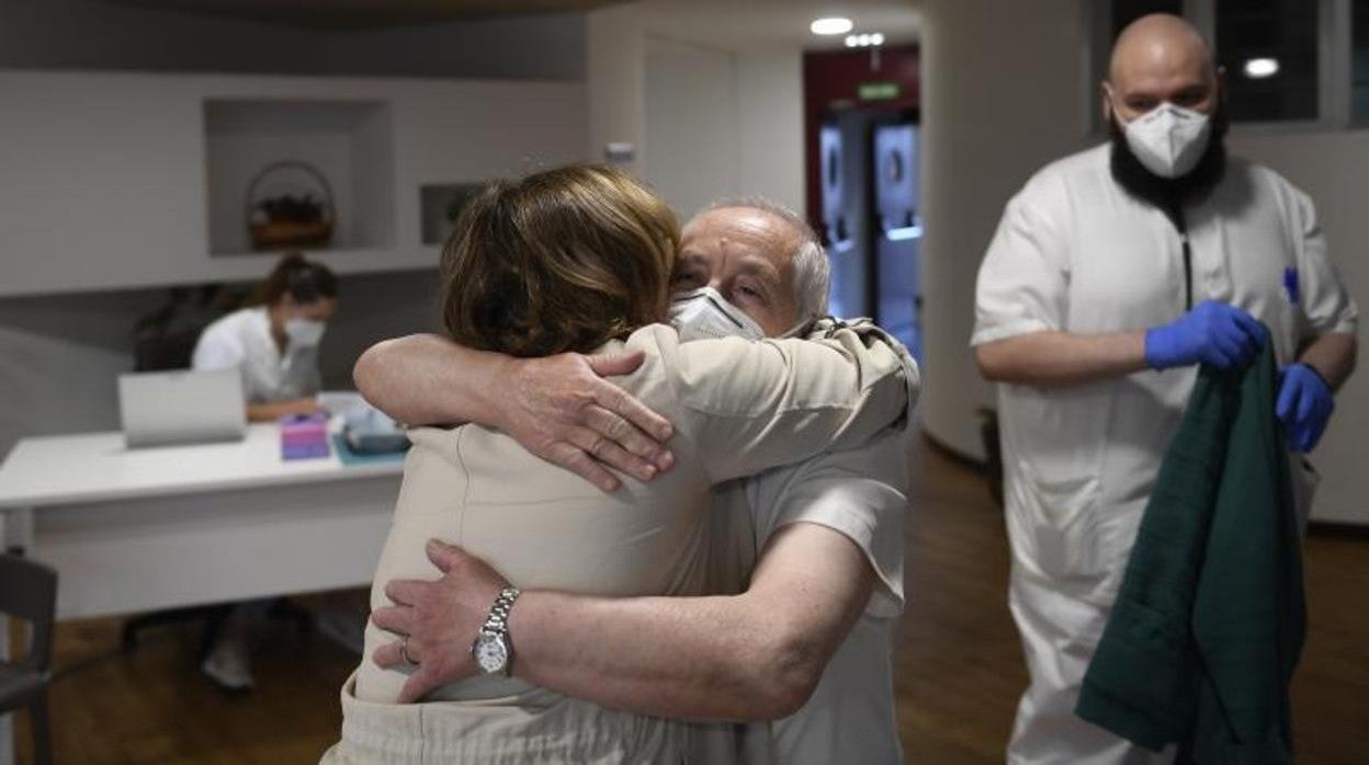 Un hombre da un abrazo tras recibir la tercera dosis de la vacuna