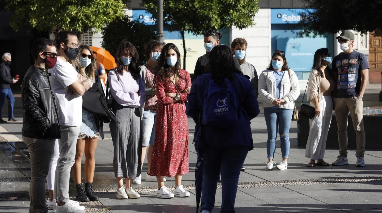 Una guía turística en la plaza de Las Tendillas con un grupo de visitantes