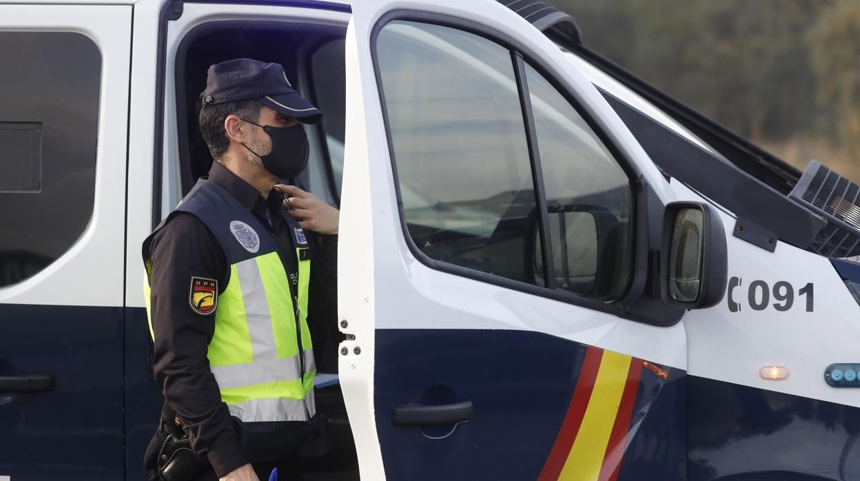 Un agente de la Policía Nacional en Córdoba junto a un furgón de intervención policial