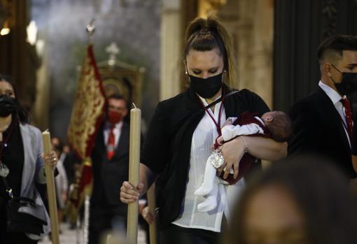 Una hermana de la Salud, con su hijo en brazos, dentro de la Catedral