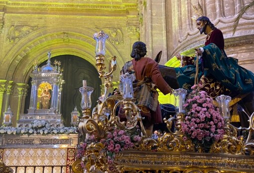 El Señor de la Pollinica pasa ante la Virgen de los Reyes, situada en un altar efímero en la puerta sur de la Catedral de Málaga