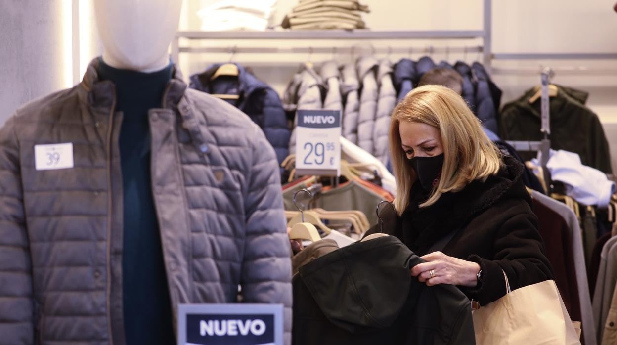 Una mujer mira ropa de abrigo en una tienda del Centro de la ciudad