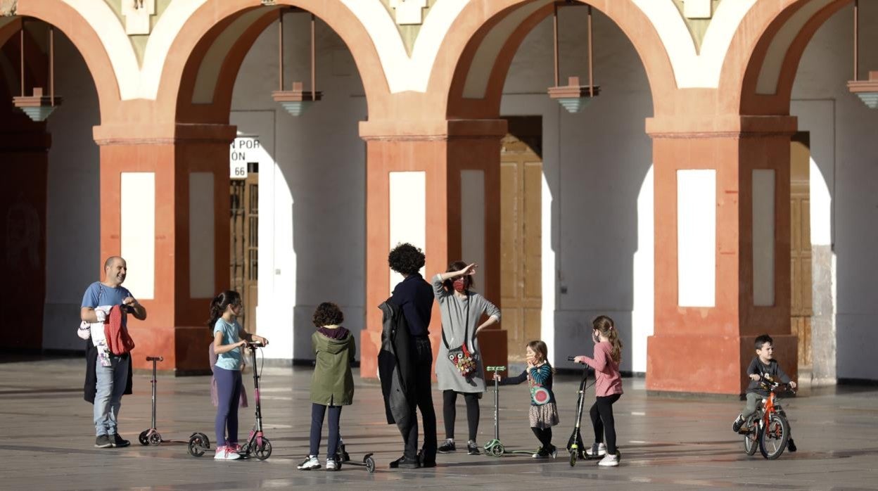 Varias familias jugando con sus niños en la plaza de la Corredera