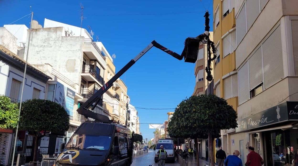 Colocación del alumbrado navideño en una calle de Puente Genil