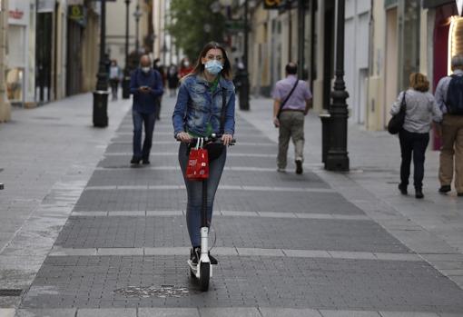 Una joven circula con su patinete por la calle Gondomar