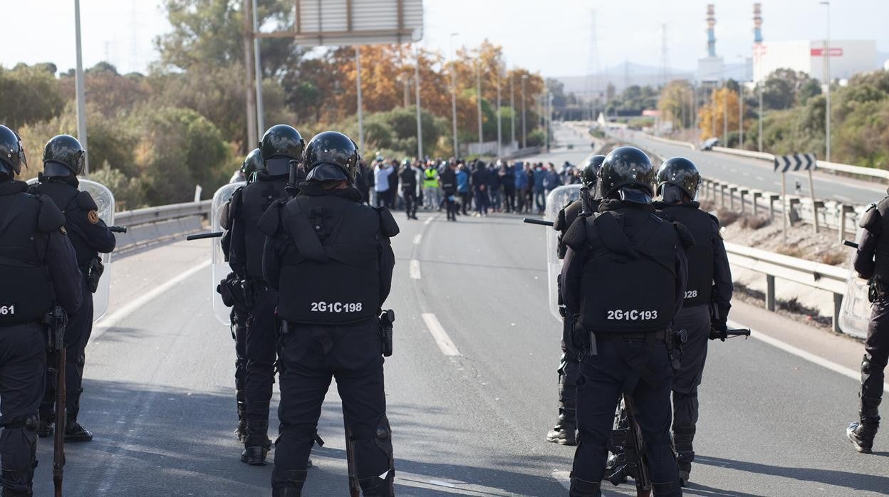 Agentes antidisturbios ante un piquete en la carretera que va a la refinería de San Roque y a La Línea