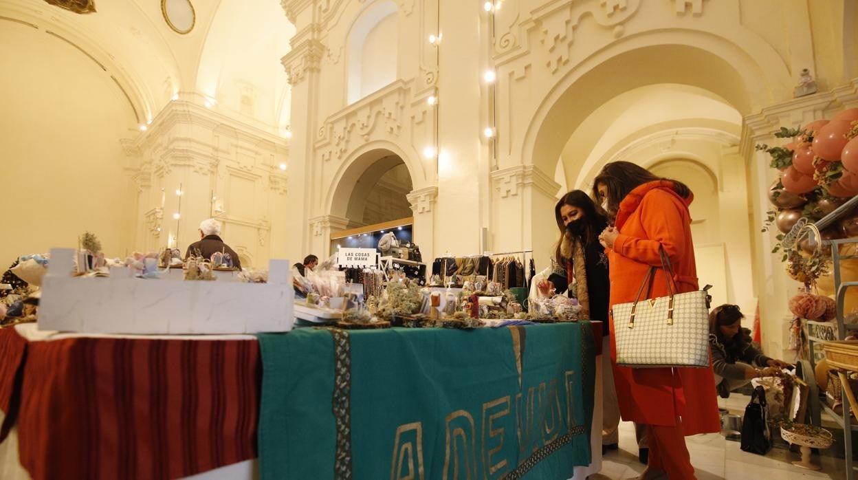 Dos mujeres miran uno de los puestos de la asociación en San Felipe Neri