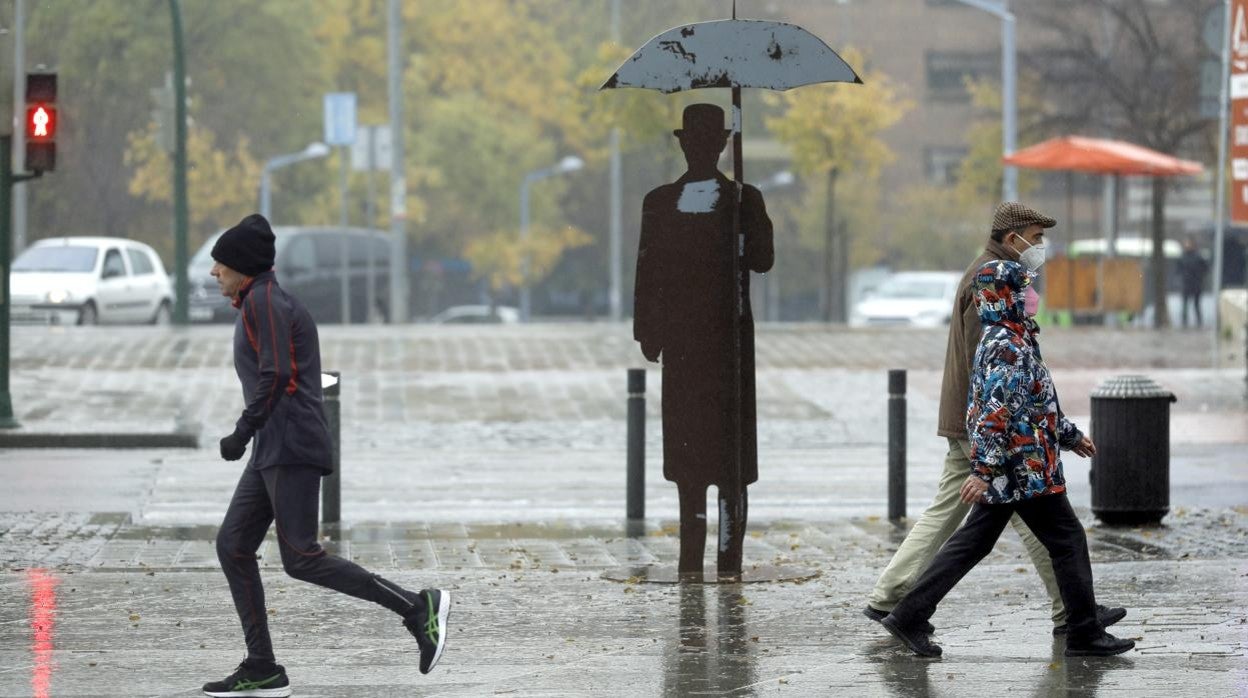 A la izquierda, un corredor bajo la lluvia