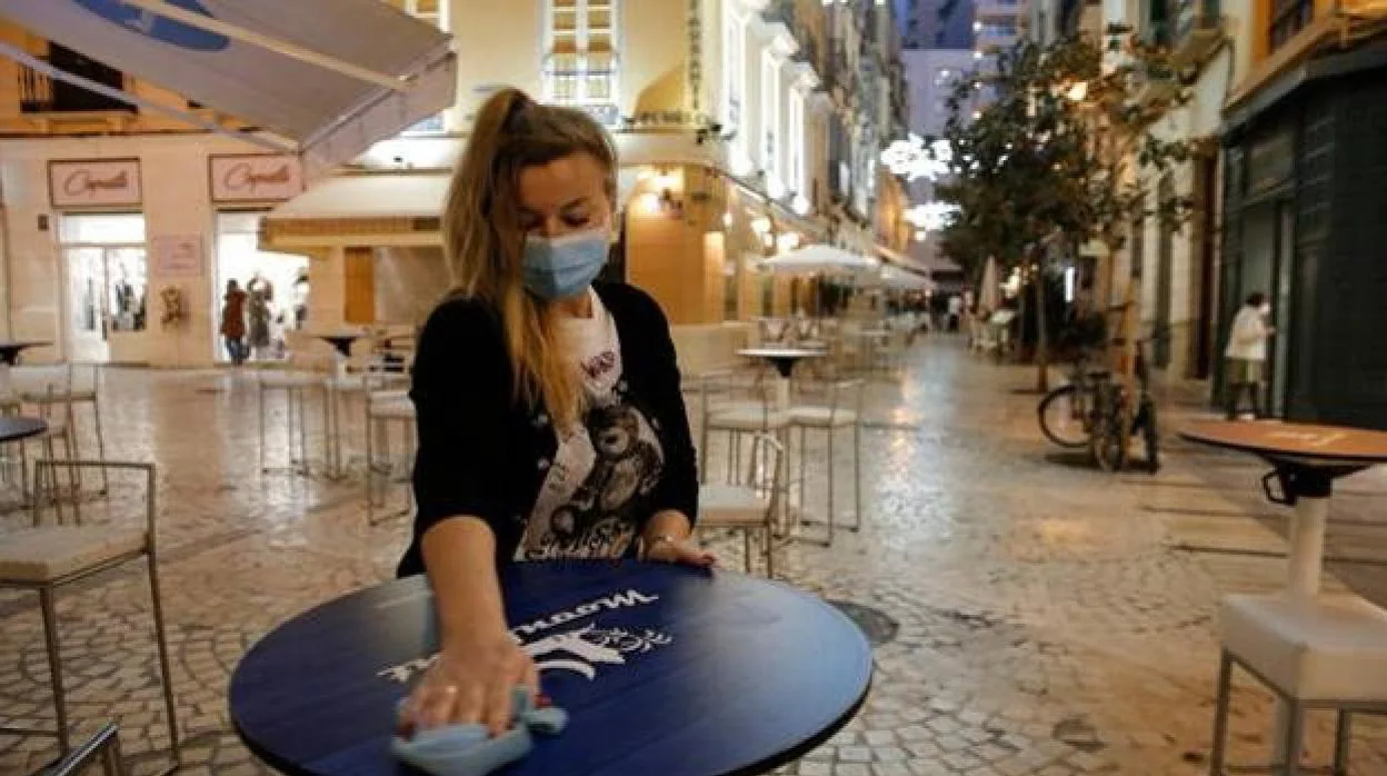 Una camarera recoge la terraza de un bar del centro de Málaga la pasada Navidad