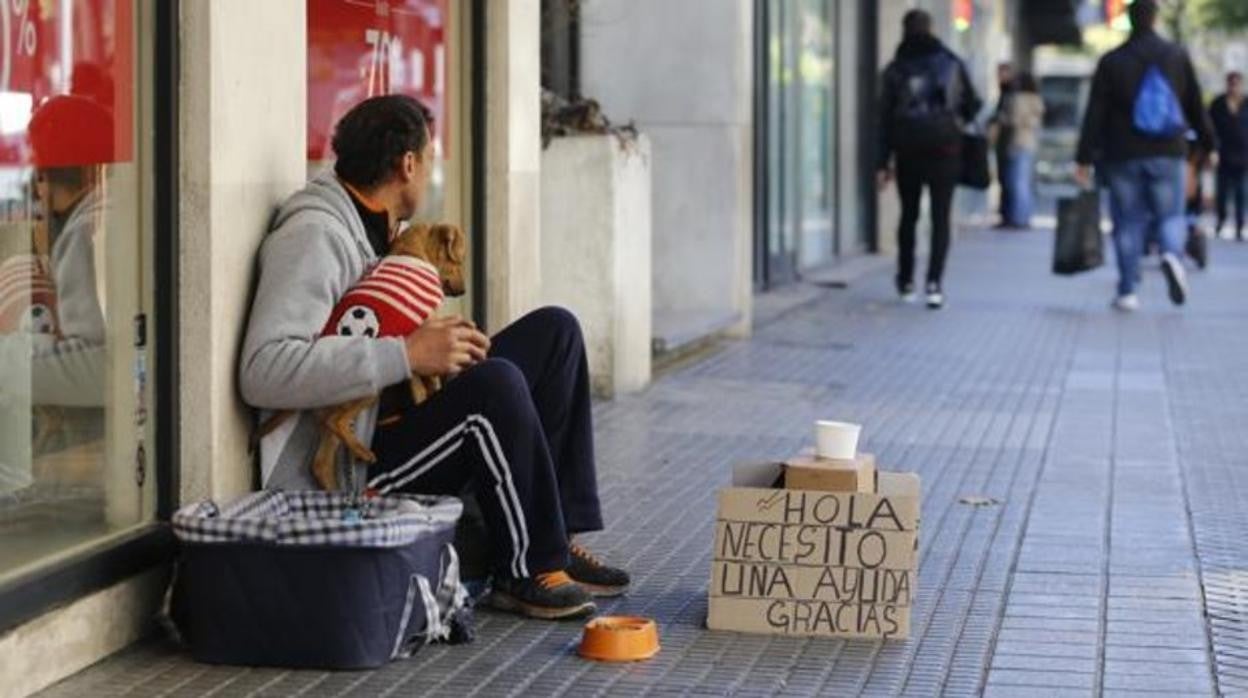 Una persona sin hogar pide limosna en una calle de Córdoba