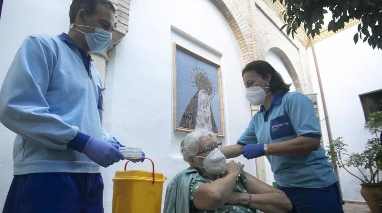 Vacunación de una anciana con la tercera dosis en una residencia de Córdoba