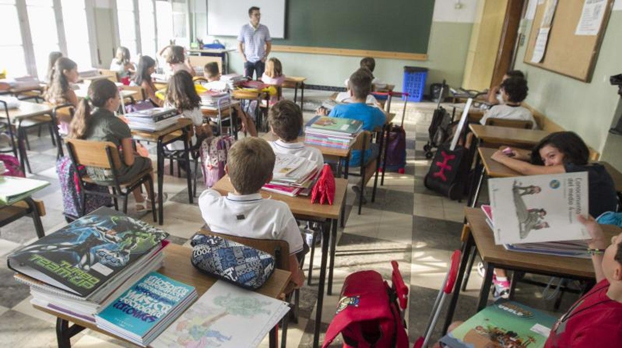 Un aula con alumnos atienden las explicaciones de su profesor