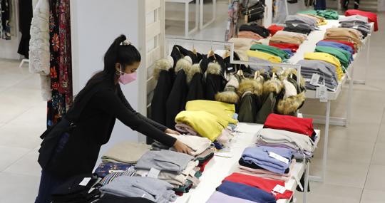 Una mujer prepara la ropa en una tienda de Córdoba