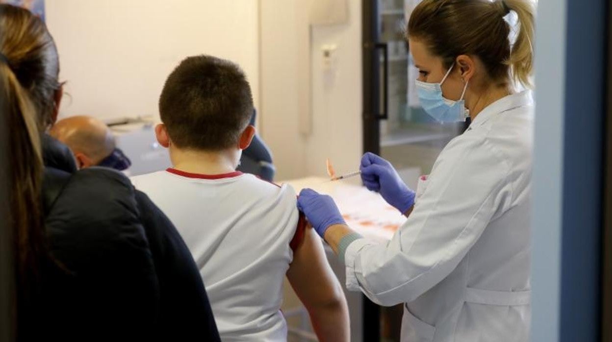 Una sanitaria vacuna a un niño en Córdoba