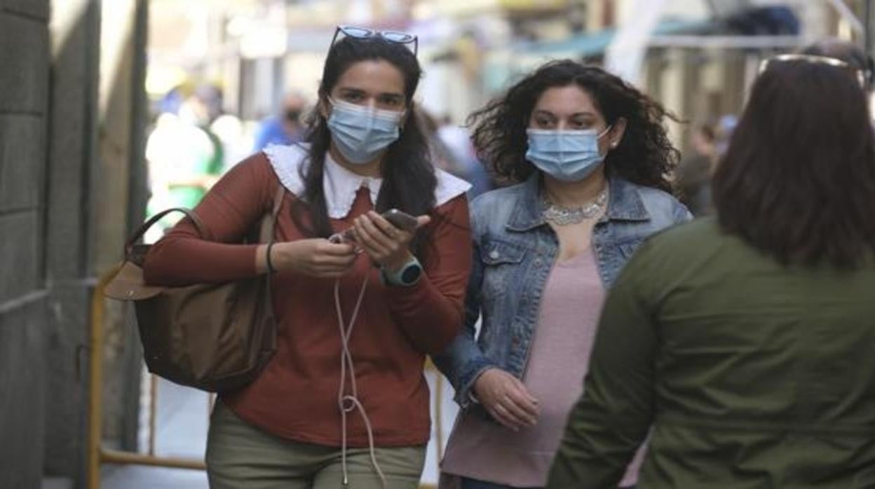 Dos gaditanas con mascarilla por la calle