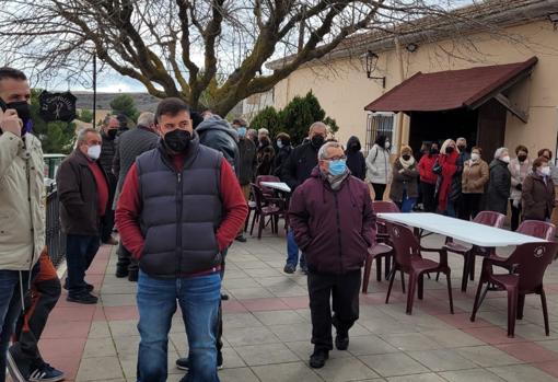 Reunión de los vecinos ante la puertas del actual bar que alberga el salón parroquial.