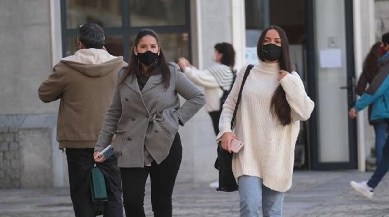 Dos jóvenes con mascarilla por la calle