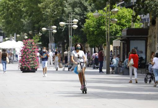 Una joven circula en patinete por una área peatonal de Córdoba