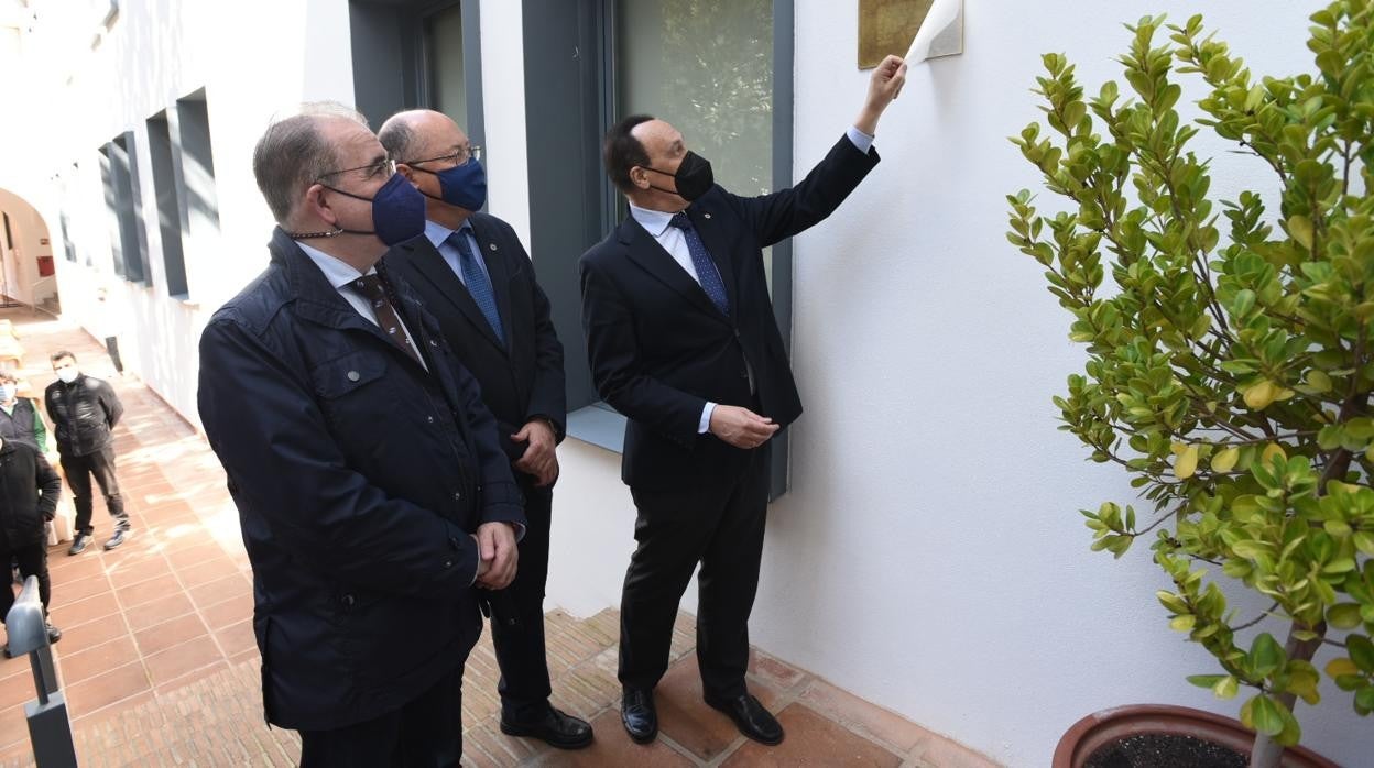 El rector de la Universidad de Córdoba despliega una placa conmemorativa de la inauguración del nuevo edificio