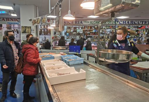 Pilar atiende a clientes en su puesto del mercado de Ciudad Jardín en la mañana del jueves