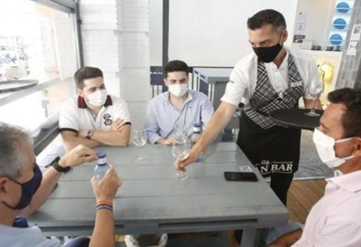 Clientes con mascarilla en el interior de un bar