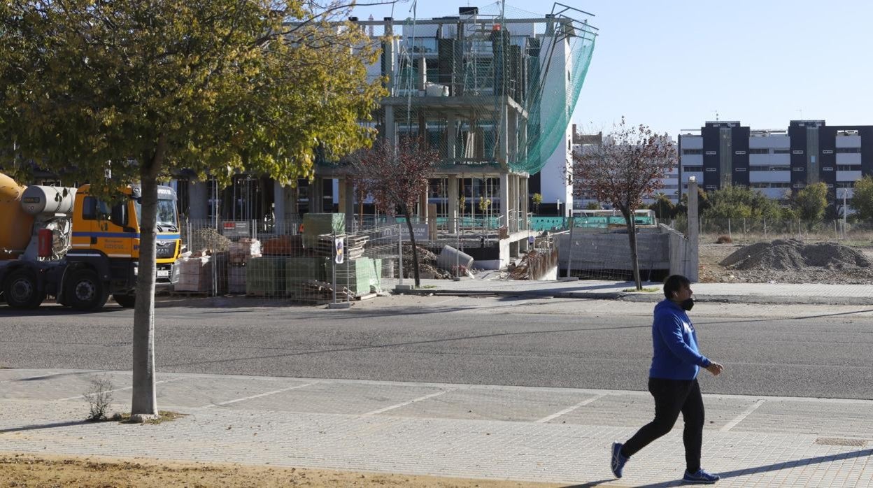 Una persona pasa delante de una promoción en construcción en la ciudad de Córdoba