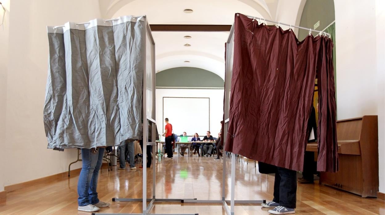 Dos electores recogen su papeleta en un colegio de Córdoba en las pasadas elecciones de 2018 en Andalucía