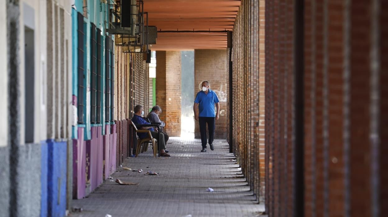 Varias personas en los soportales de los bloques de Palmeras, uno de los barrios más pobres de España