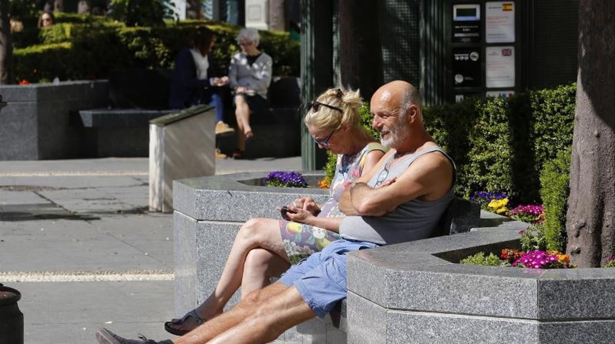 Una pareja disfruta del sol en la plaza de las Tendillas