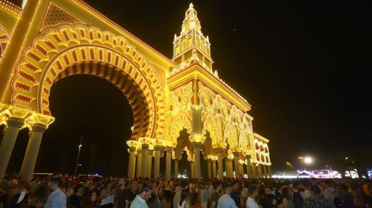 Cordobeses bajo la portada de la Feria hace unos días