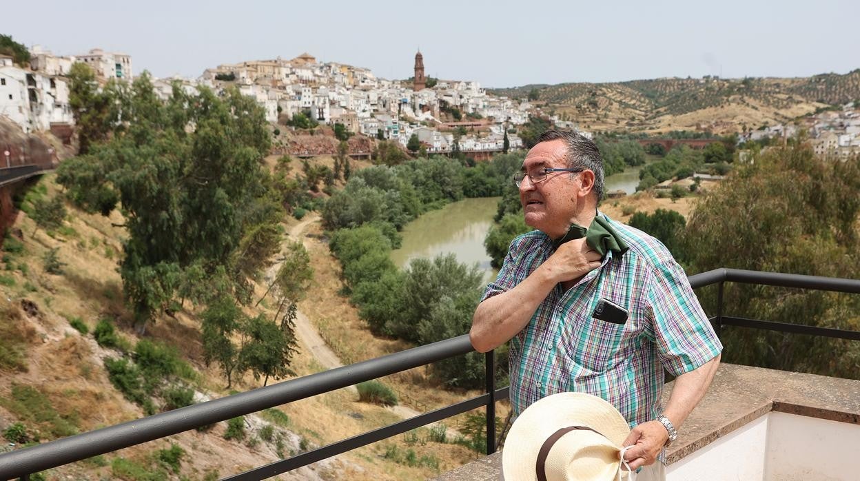 Un hombre se seca el sudor con un pañuelo con el meandro de Montoro y el Guadalquivir de fondo