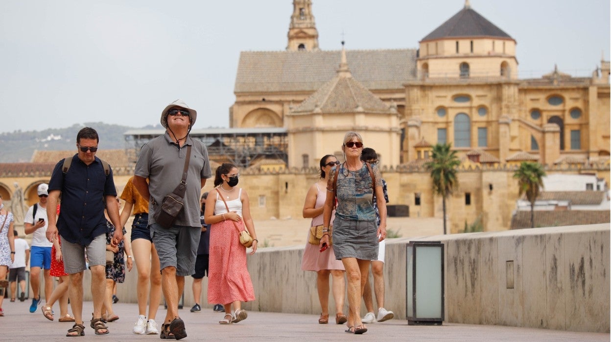 Turistas paseando por el Puente Romano, con la Mezquita-Catedral al fondo