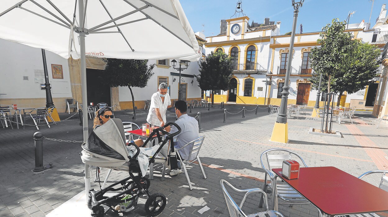 Una pareja sentada en una terraza junto al Ayuntamiento de Almodóvar del Río