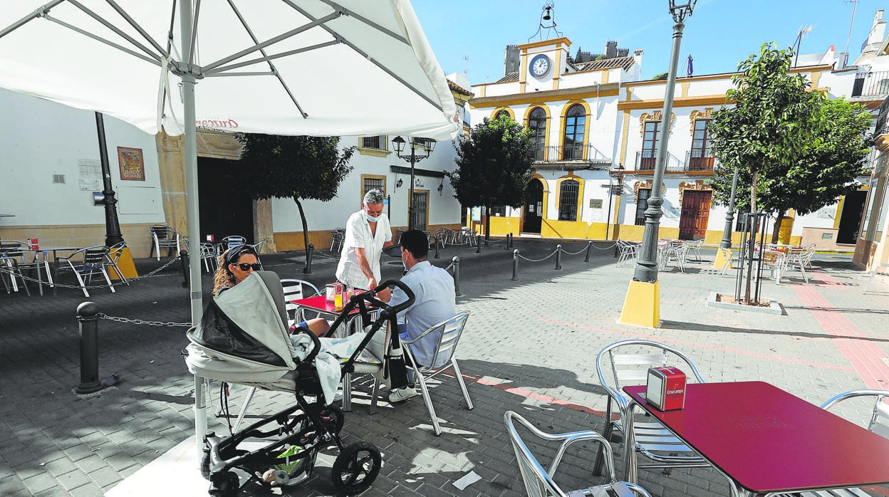 Una pareja sentada en una terraza junto al Ayuntamiento de Almodóvar del Río