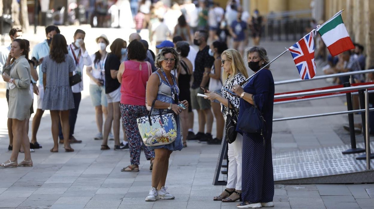 Una guía de turistas internacionales espera a su grupo en el Patio de los Naranjos