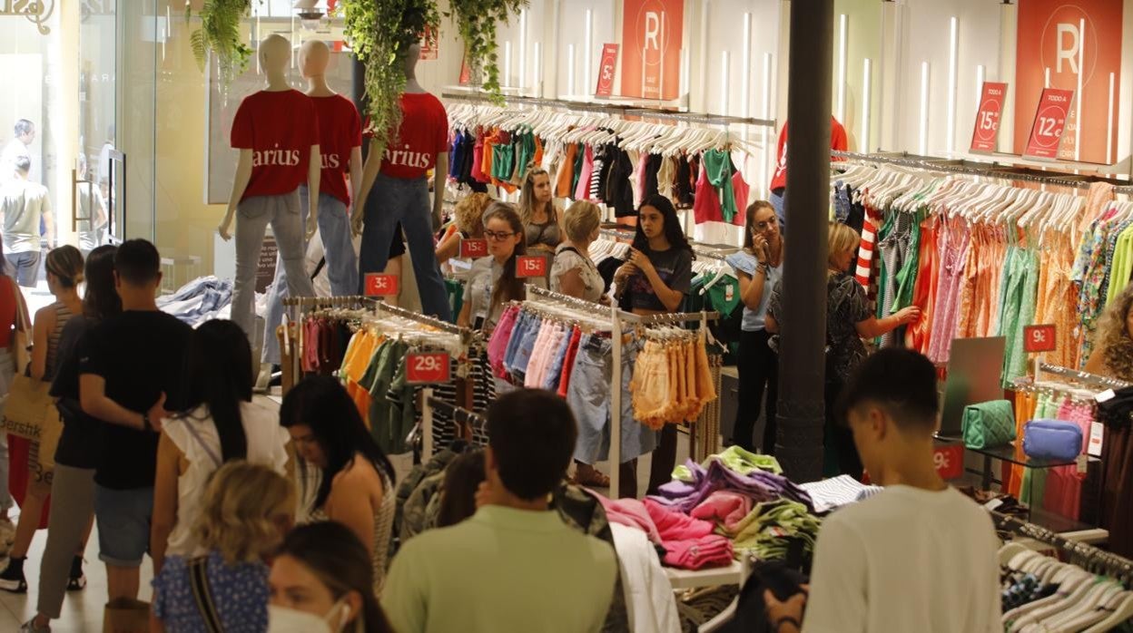 Clientes comprando en una tienda del centro que ya ha iniciado las rebajas