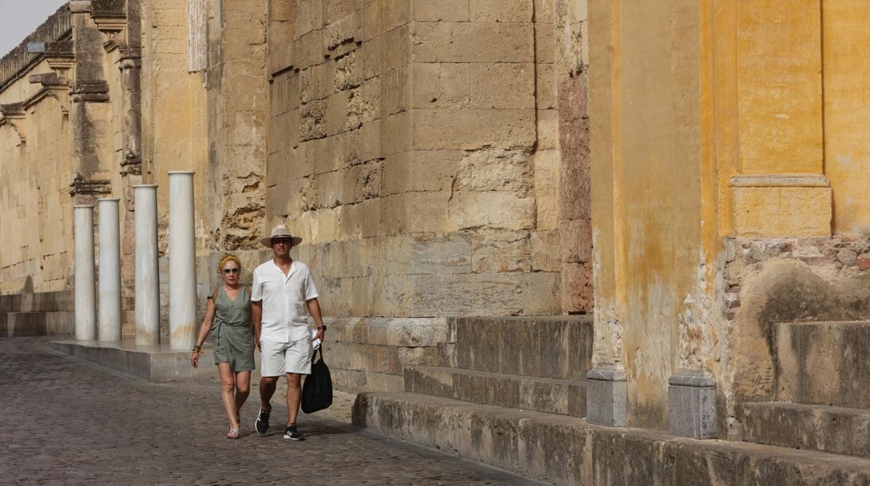 Dos personas pasean un día de calor junto a la Mezquita-Catedral de Córdoba