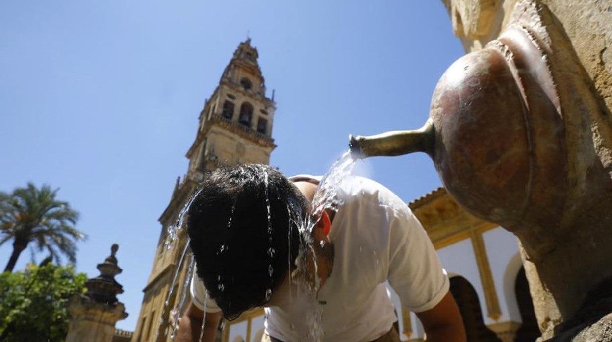 Un turista se refresca en una fuente del Patio de los Naranjos