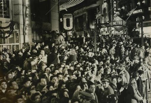 El público se agolpa en las aceras de la plaza del Callao para ver pasar al presidente.