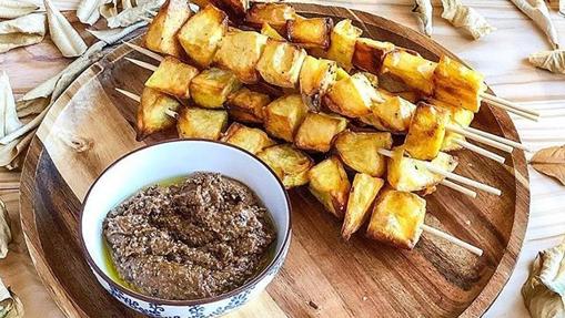 Brochetas de patata con pesto de tomate.