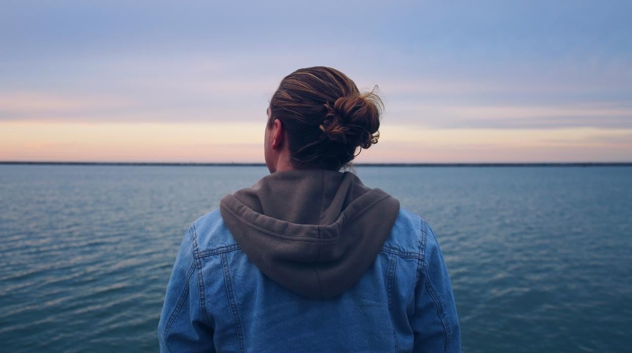 Un joven, preocupado, mirando al horizonte.