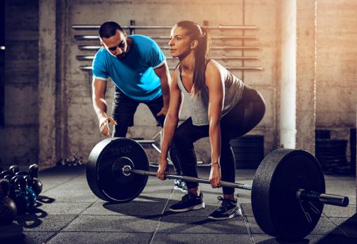 Un entrenador, durante una sesión de entrenamiento de fuerza.