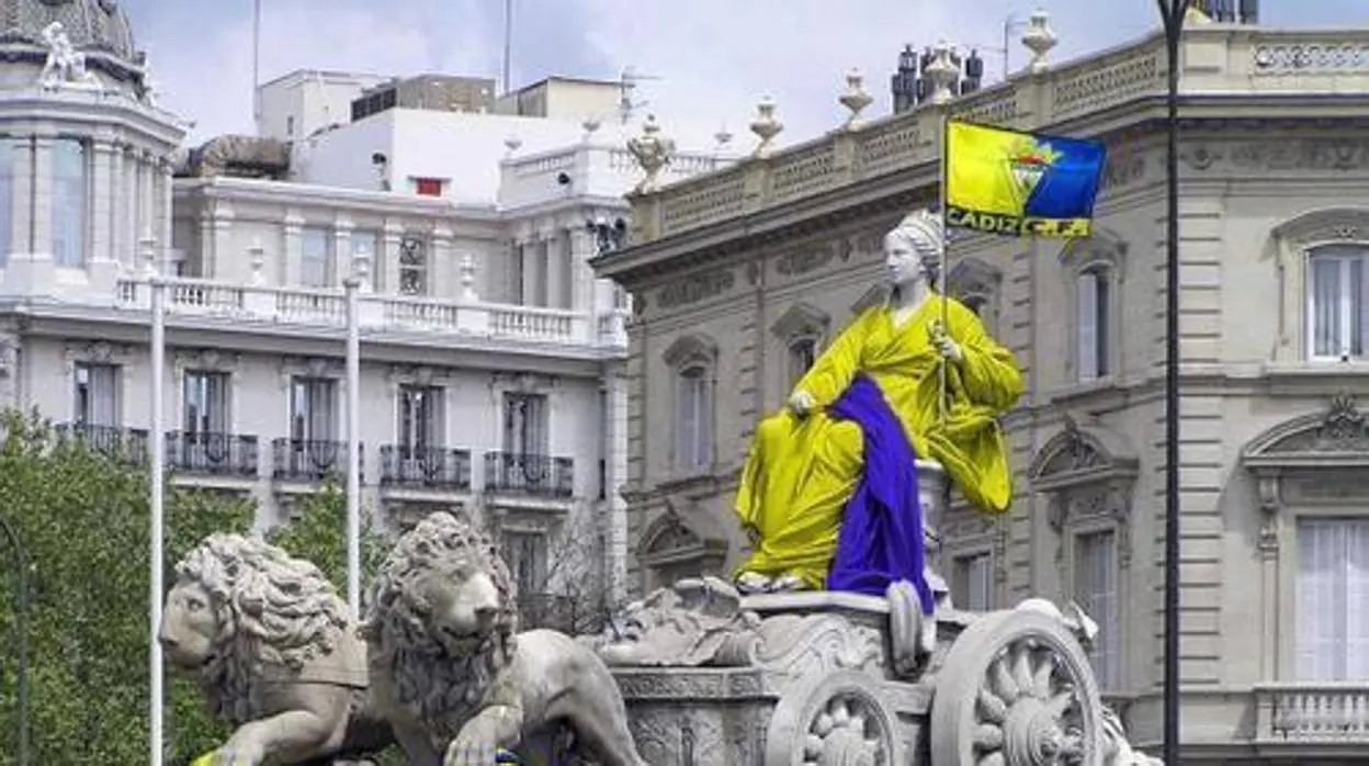 Montaje de la estatua de La Cibeles con la bandera cadista, de amarillo y azul.